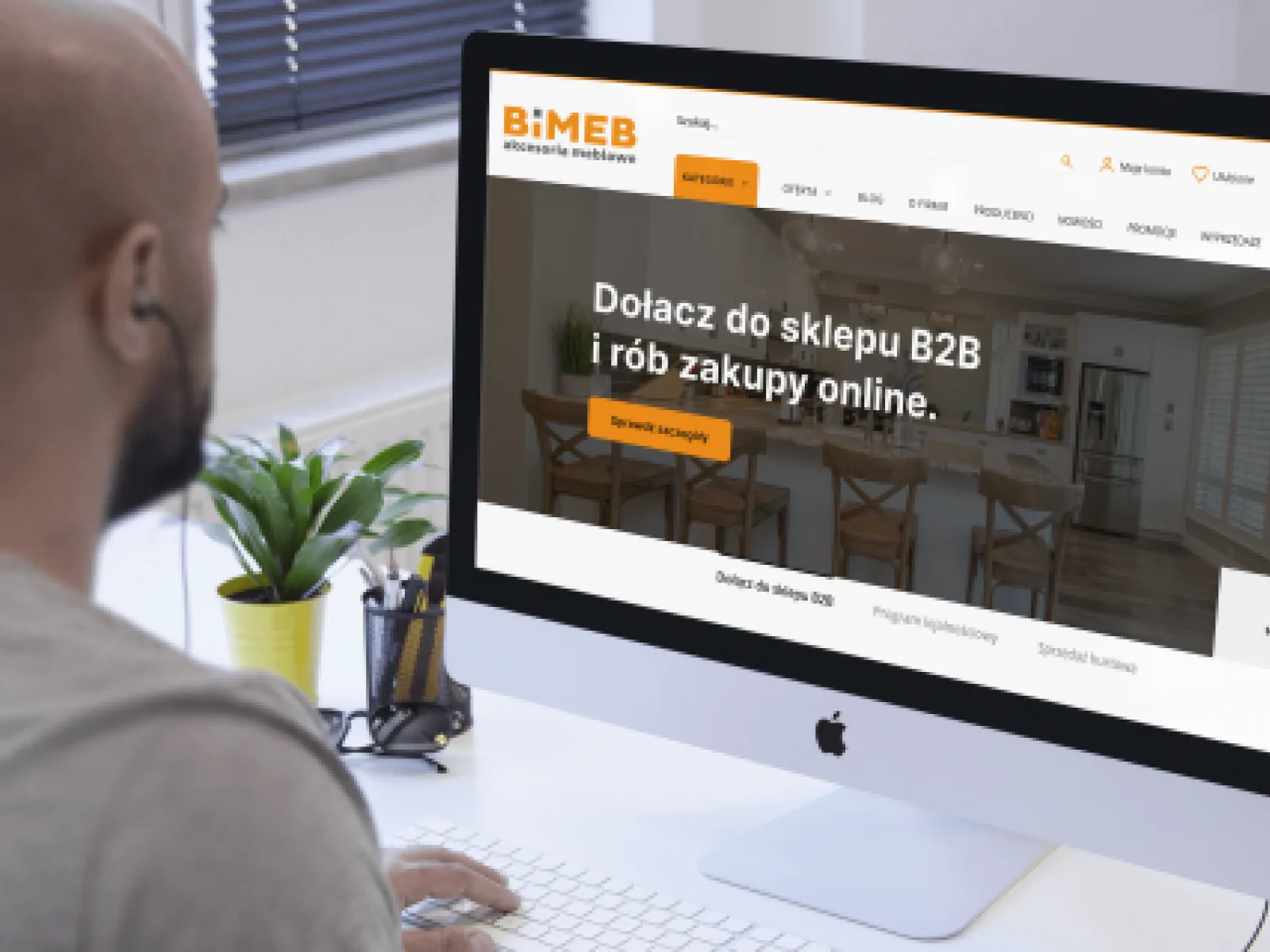 Person at a desk viewing a desktop B2B storefront homepage